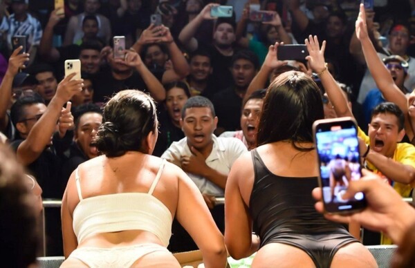 Two women expose buttocks for a beer at Carnival in Panama