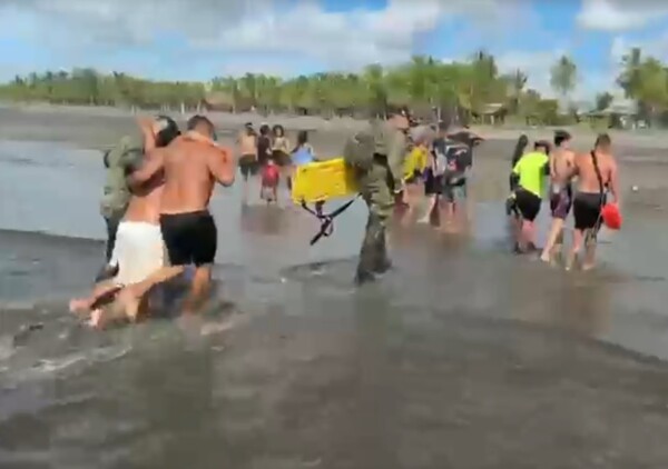 Two young men rescued after being swept away by current at beach